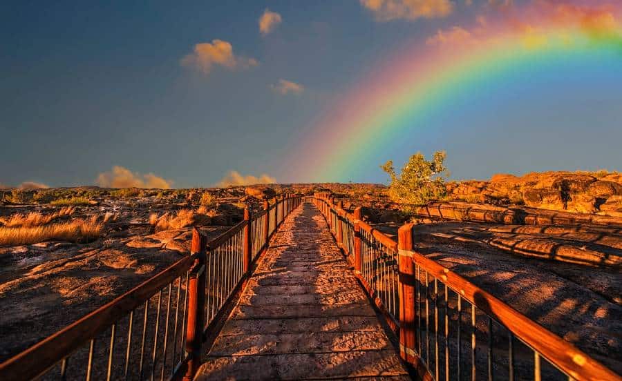 Path in desert with rainbow at the end.